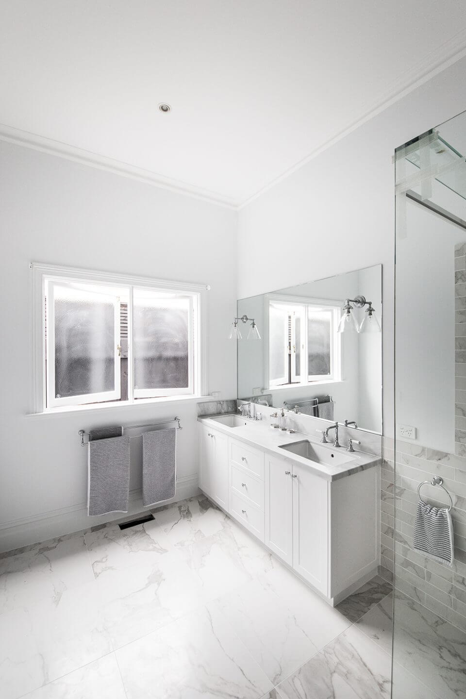 A custom designed bathroom featuring chrome fixtures. Designed and built by MJ Harris Group.