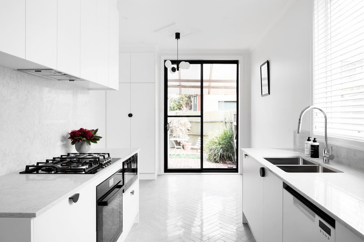 A custom designed kitchen featuring herringbone tiling floor and a caesar stone benchtop. Designed and built by MJ Harris Group. #MJHxNewrySt