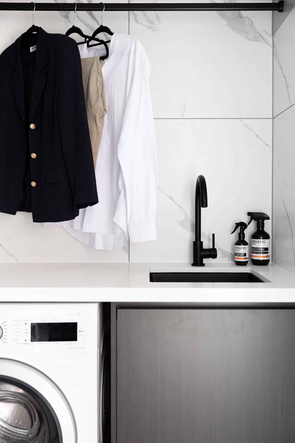 A custom designed laundry featuring marble look tiles. Designed and built by MJ Harris Group.