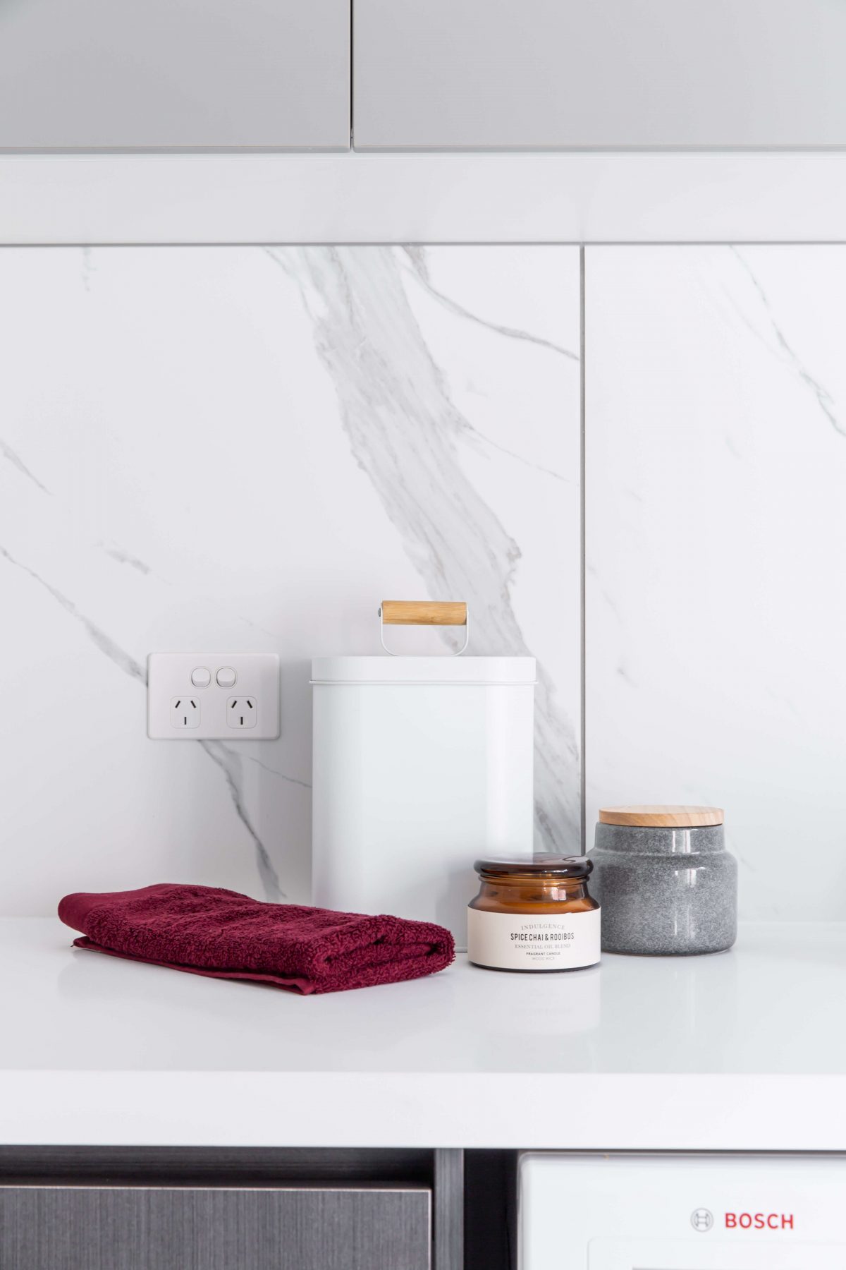 A custom designed laundry featuring marble look tiles. Designed and built by MJ Harris Group.