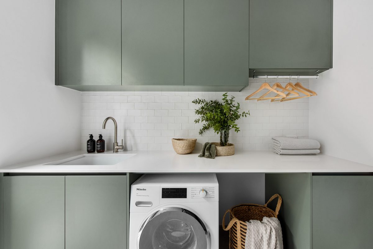 A custom designed laundry featuring a white splashback and custom green joinery. Designed and built by MJ Harris Group. #MJHxHalifaxSt