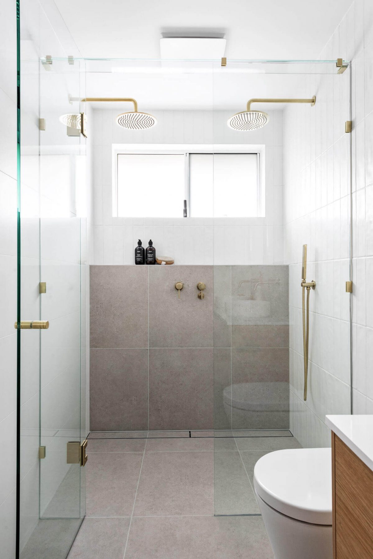 A custom designed bathroom featuring a double shower and gold accents. Designed and built by MJ Harris Group. #MJHxThompsonSt
