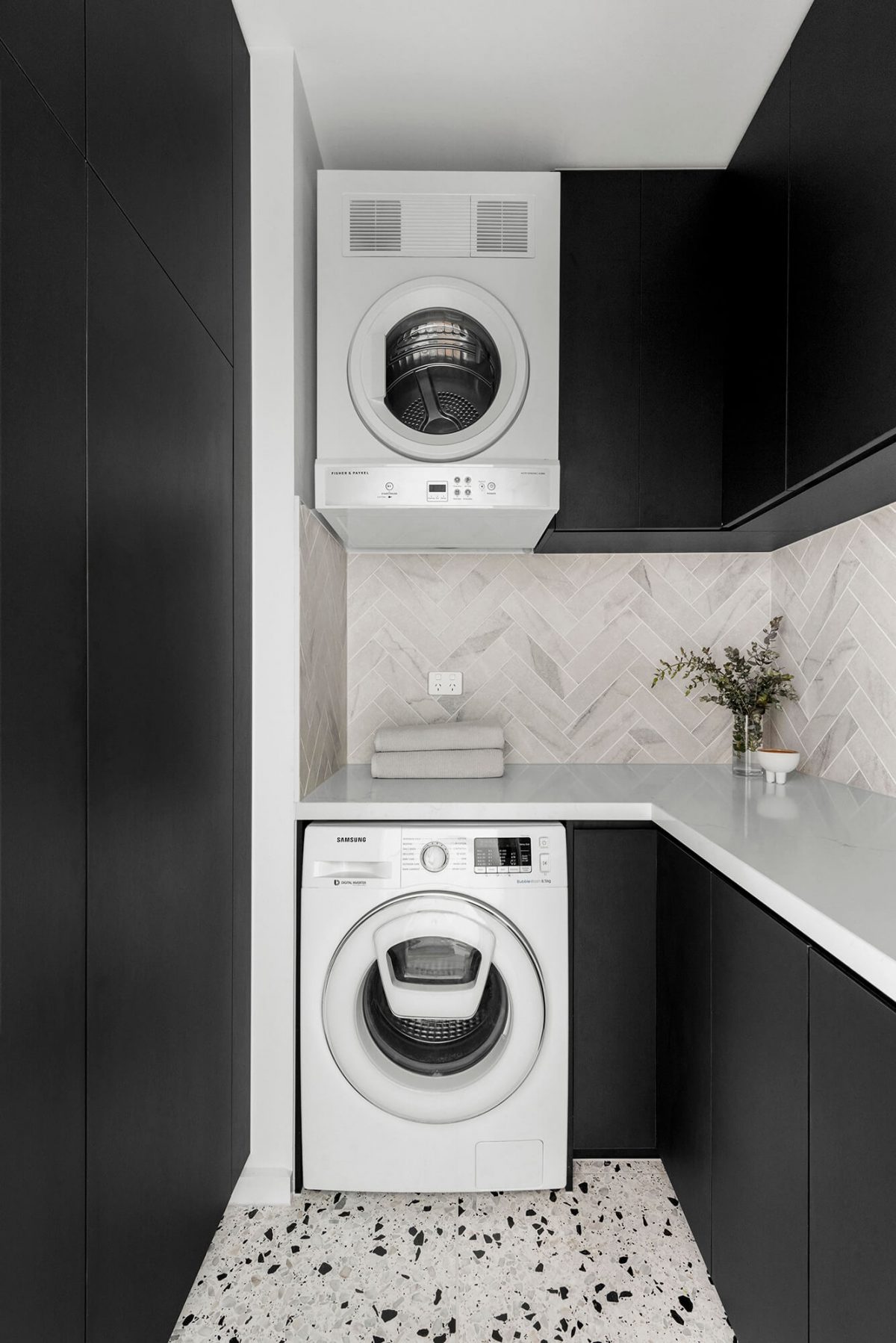 A custom designed laundry featuring a tiled herringbone splashback and custom joinery. Designed and built by MJ Harris Group. #MJHxBaySt