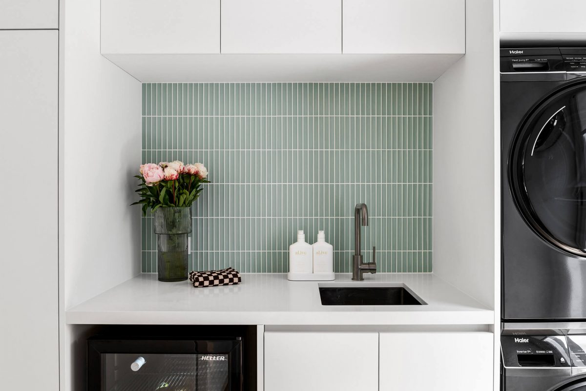 Brighton combined space kitchen renovation butlers pantry and laundry room green concave tiles, white custom joinery, brushed gunmetal tapware, black washing machine, black dryer, wine fridge
