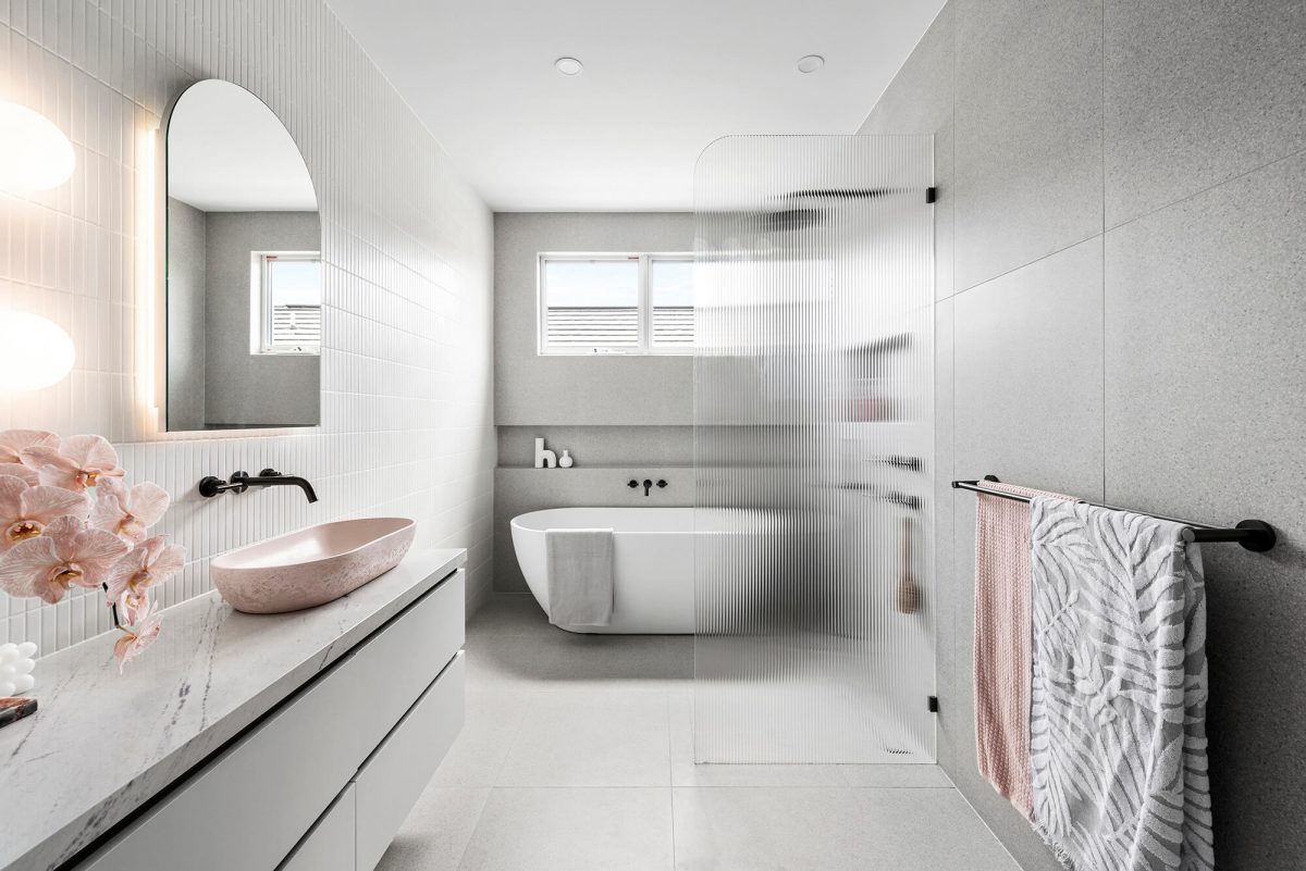 A custom designed bathroom featuring a pink basin and brushed gunmetal tapware. Designed and built by MJ Harris Group. #MJHxGlencairnAve