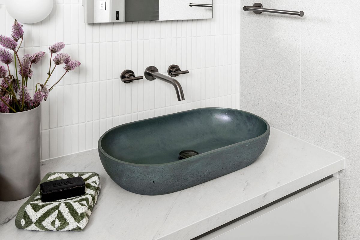 A custom designed bathroom featuring an olive green basin and brushed gunmetal tapware. Designed and built by MJ Harris Group. #MJHxGlencairnAve