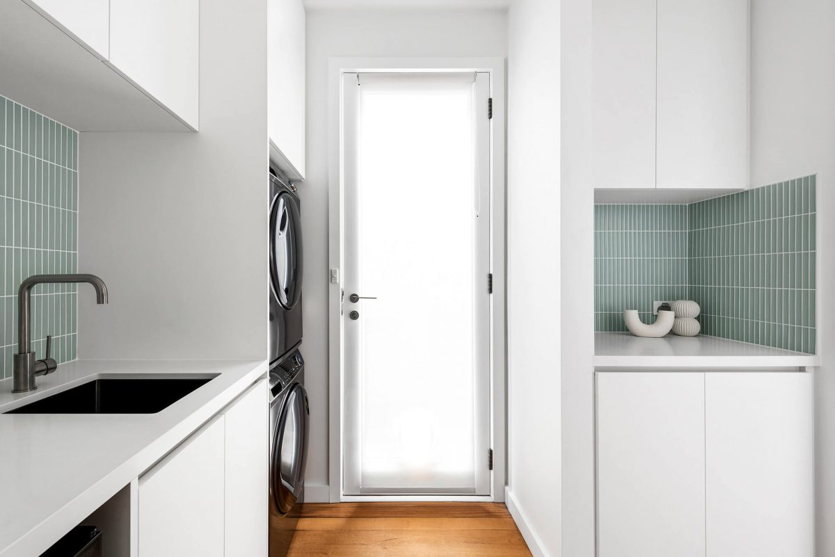 A custom designed combined space kitchen renovation including a butlers pantry and a laundry room featuring green concave tiles and white custom joinery. Designed and built by MJ Harris Group. #MJHxGlencairnAve