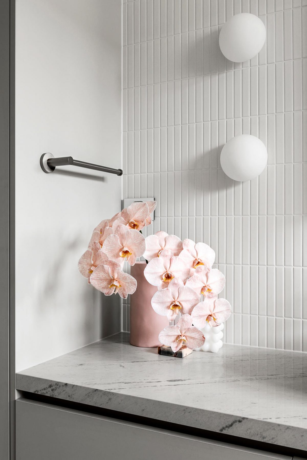 Bathroom renovation Brighton, Melbourne with stone benchtop, white kitkat feature wall, brushed gunmetal tapware, custom joinery