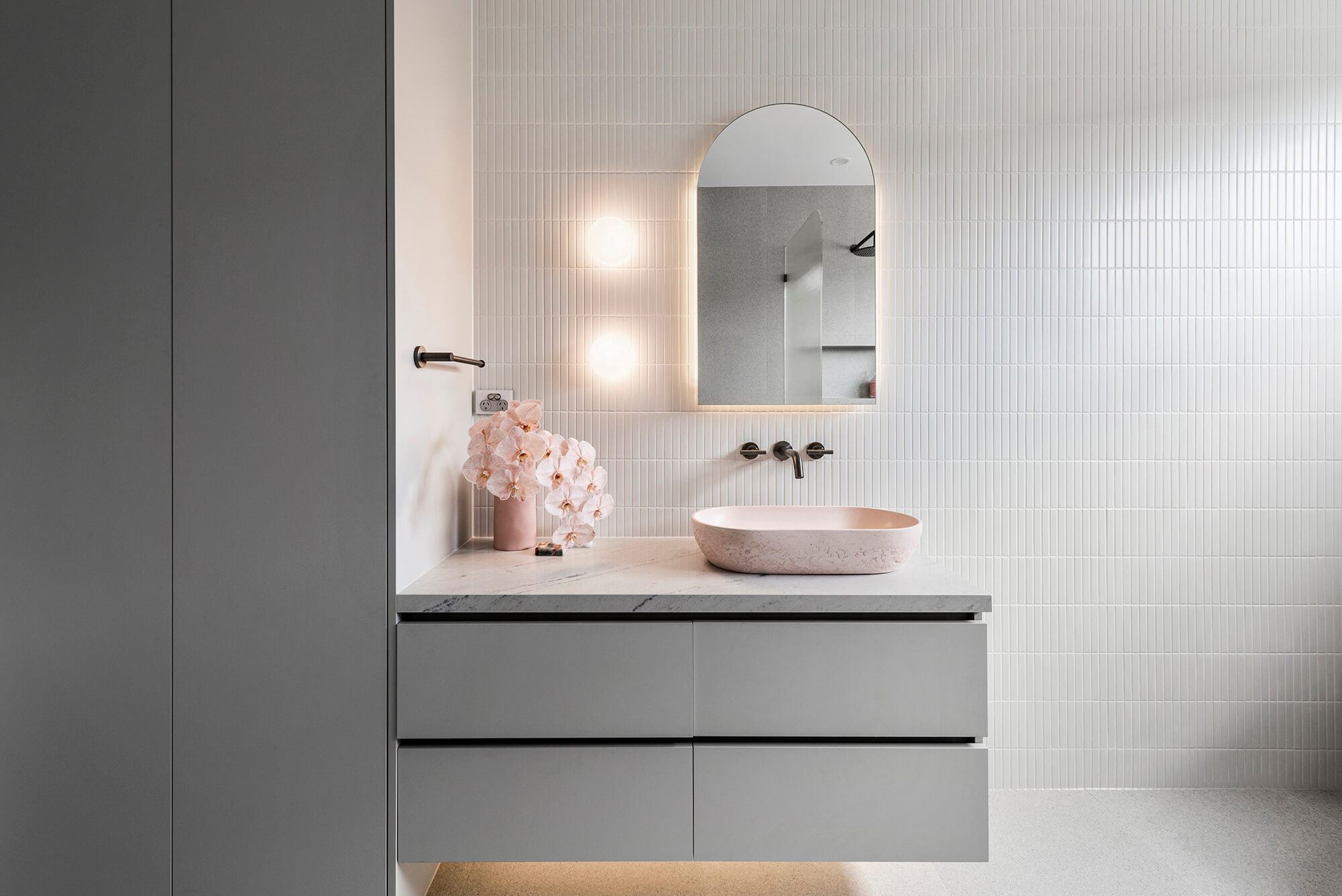 A custom designed bathroom featuring a pink basin and brushed gunmetal tapware. Designed and built by MJ Harris Group. #MJHxGlencairnAve