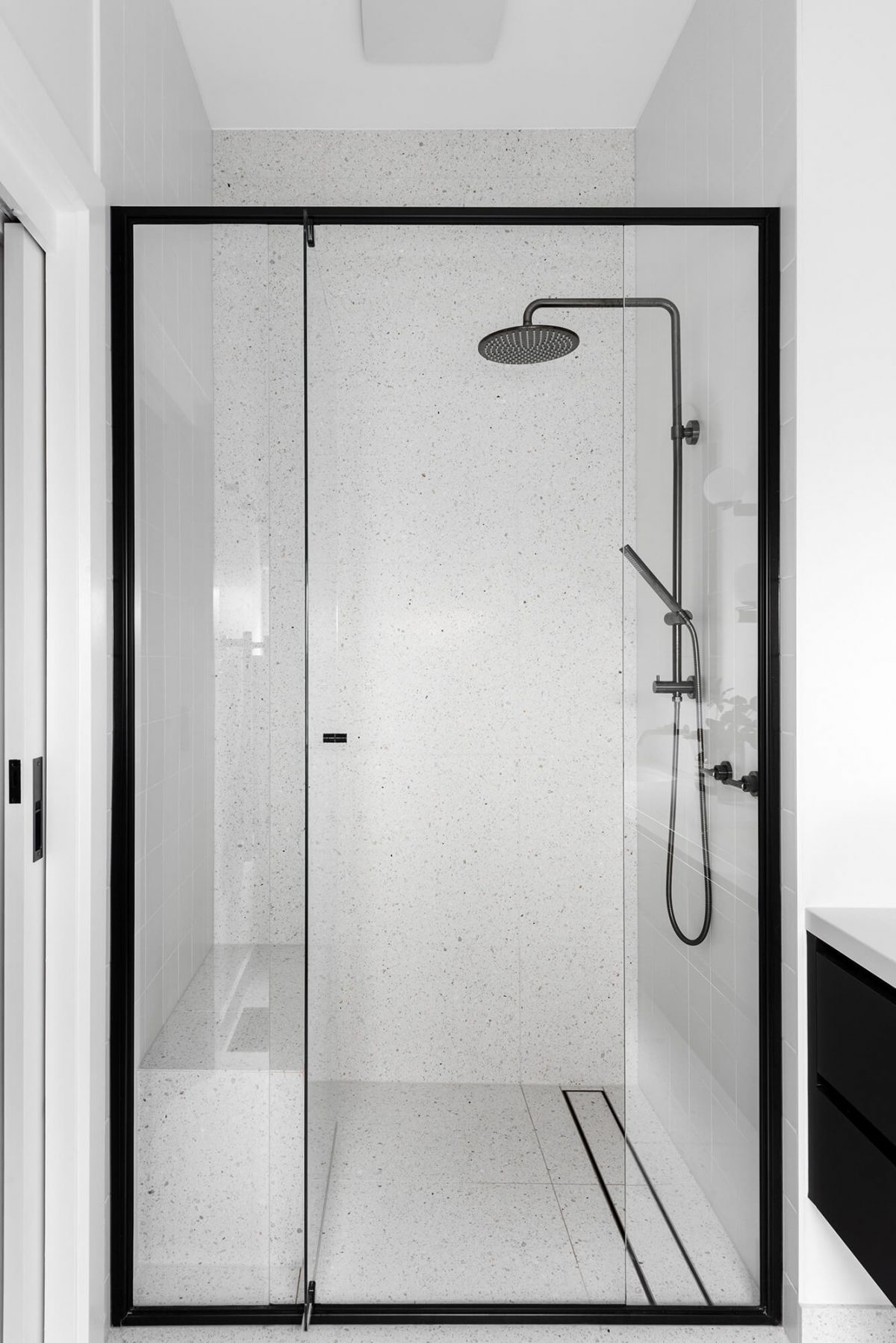 A custom designed bathroom featuring gunmetal fixtures and a terrazzo shower seat. Designed and built by MJ Harris Group. #MJHxGrandviewGr