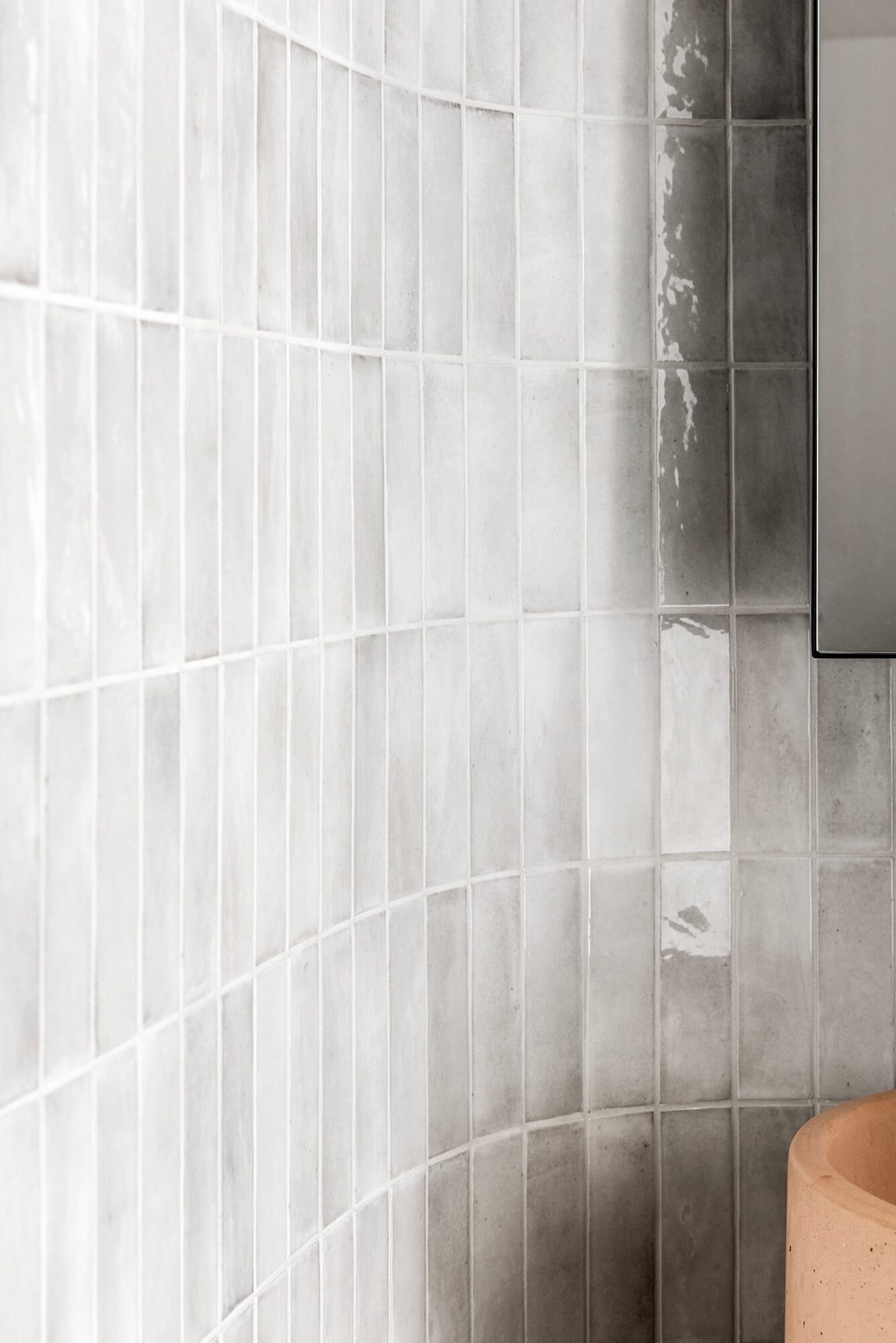 A custom designed bathroom featuring a curved tiled feature wall and pink concrete pillar basin. Designed and built by MJ Harris Group. #MJHxPeppinSt