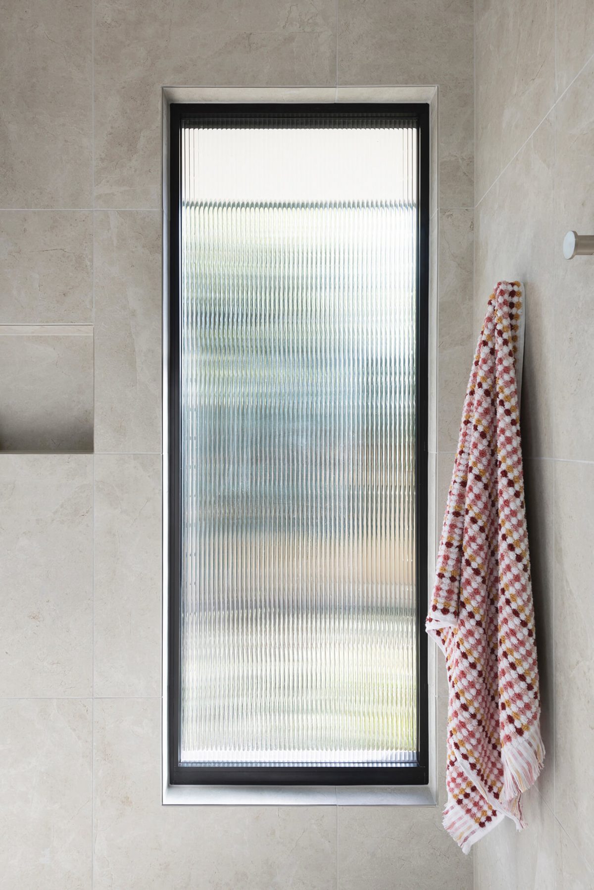 A custom designed bathroom featuring a window with fluted glass. Designed and built by MJ Harris Group. #MJHxWallisAve