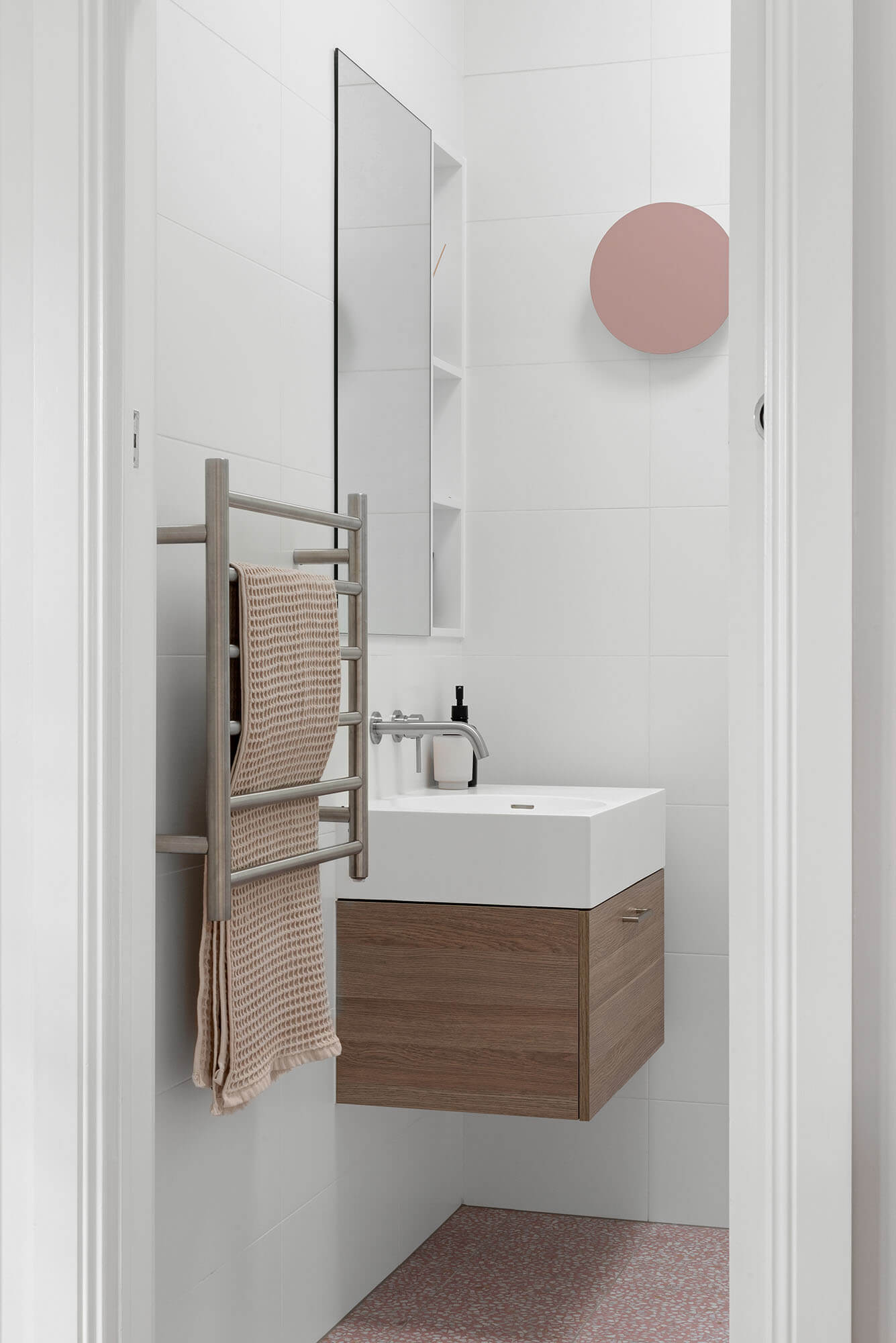 A custom designed bathroom featuring pink tiles. Designed and built by MJ Harris Group.