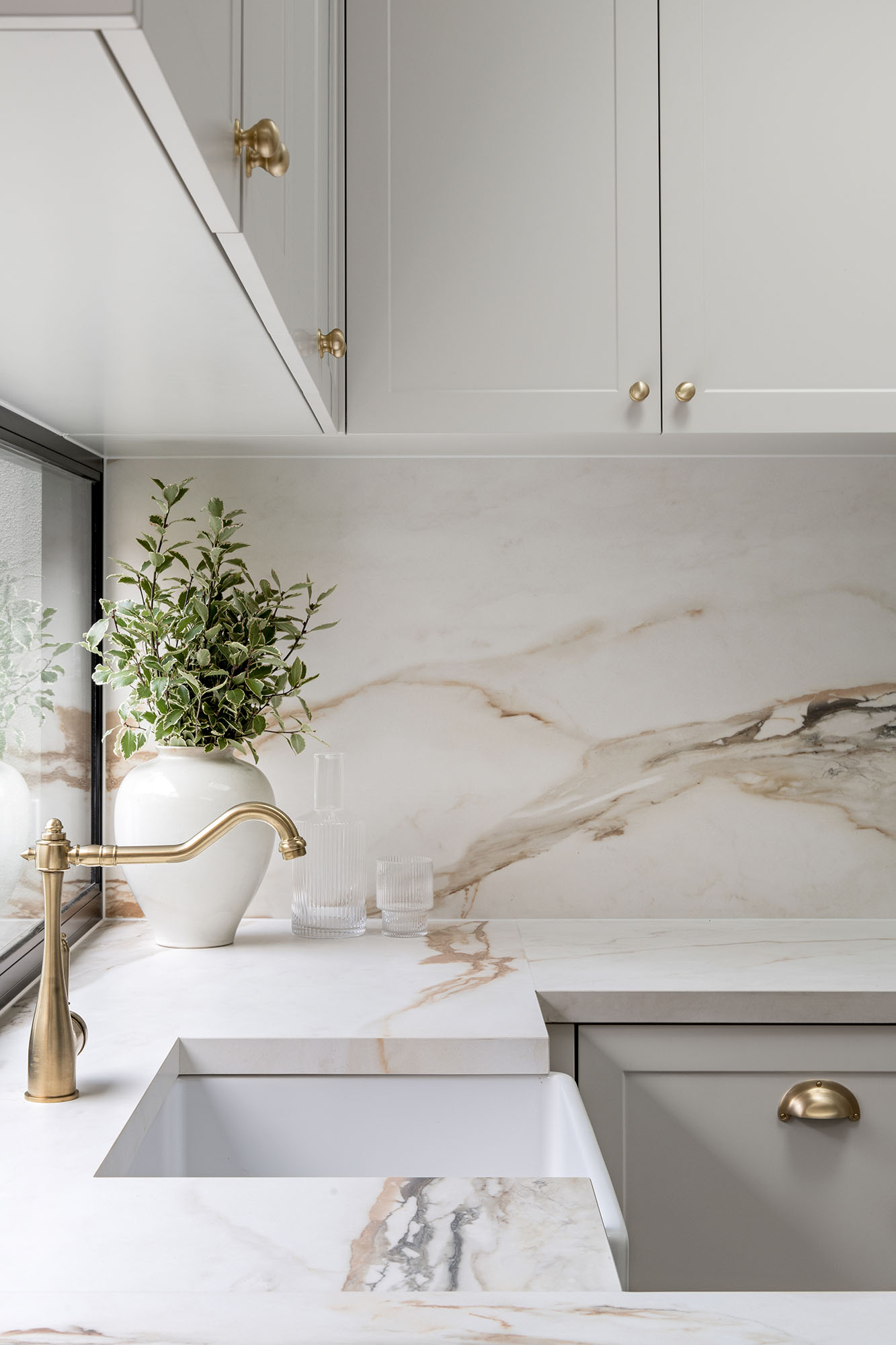 A custom designed kitchen featuring a porcelain surface splash back and bench top in Grand Paradiso. Designed and built by MJ Harris Group.