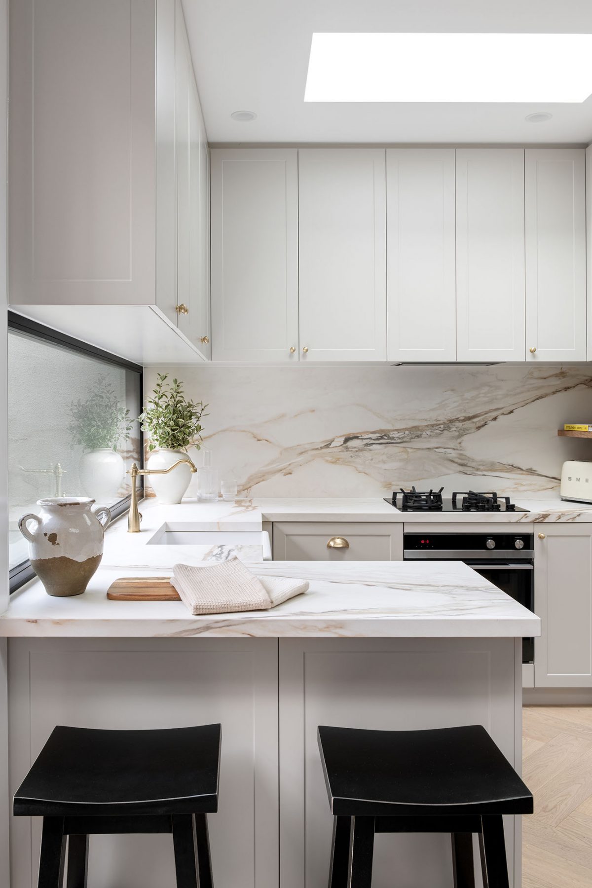 A custom designed kitchen featuring a porcelain surface splash back and bench top in Grand Paradiso. Designed and built by MJ Harris Group. #MJHxMacaylayRd