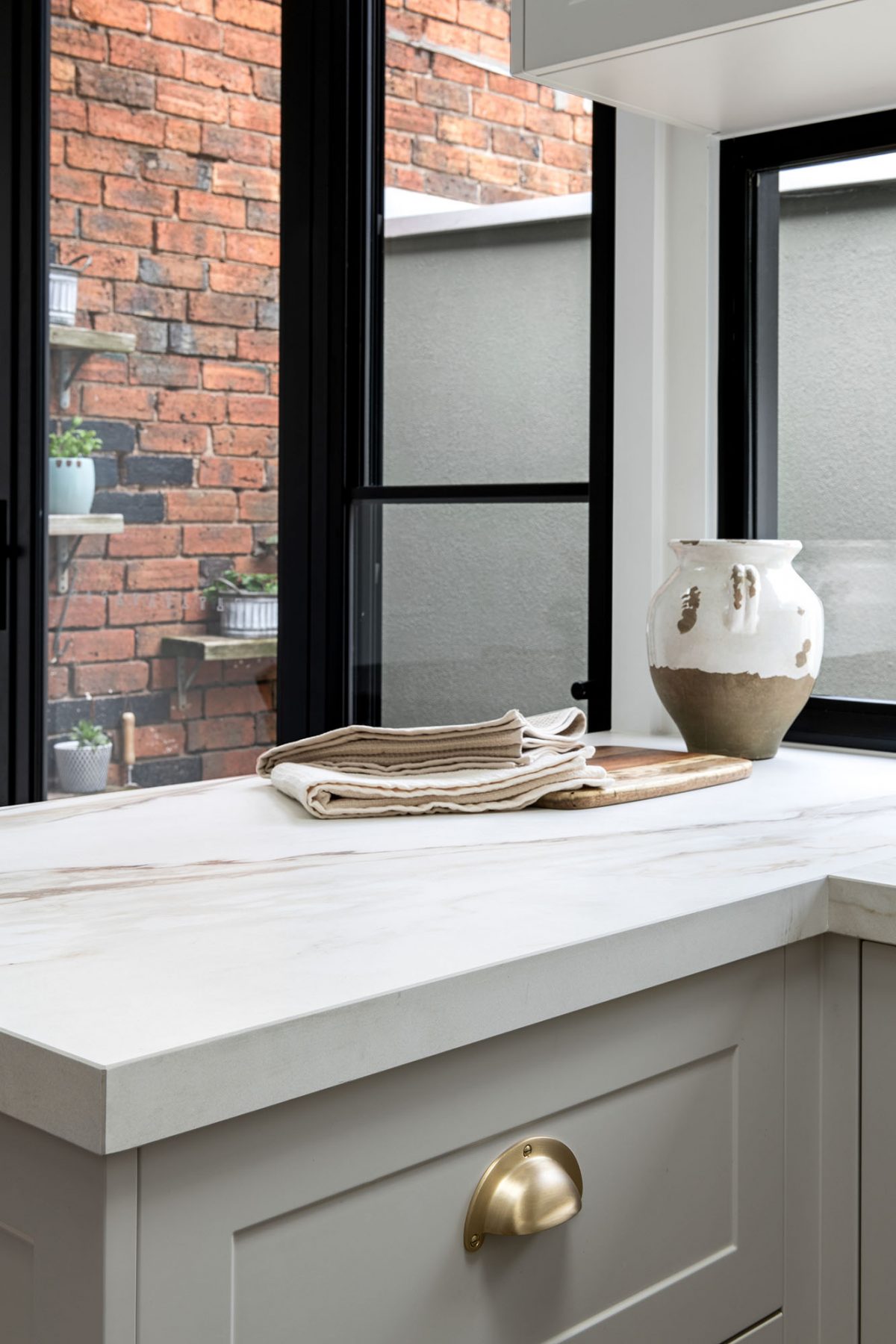 A custom designed kitchen featuring a porcelain surface splash back and bench top in Grand Paradiso. Designed and built by MJ Harris Group. #MJHxMacaylayRd