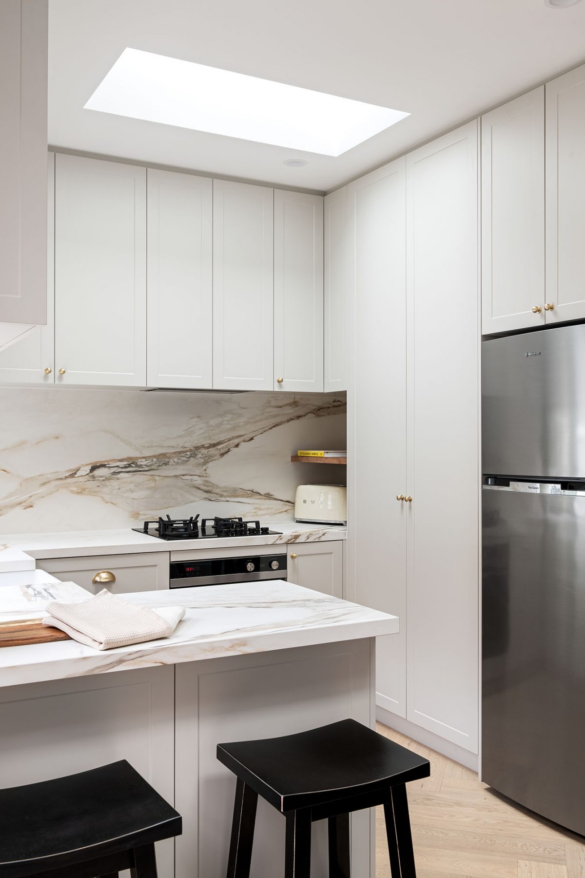 A custom designed kitchen featuring a porcelain surface splash back and bench top in Grand Paradiso. Designed and built by MJ Harris Group. #MJHxMacaylayRd