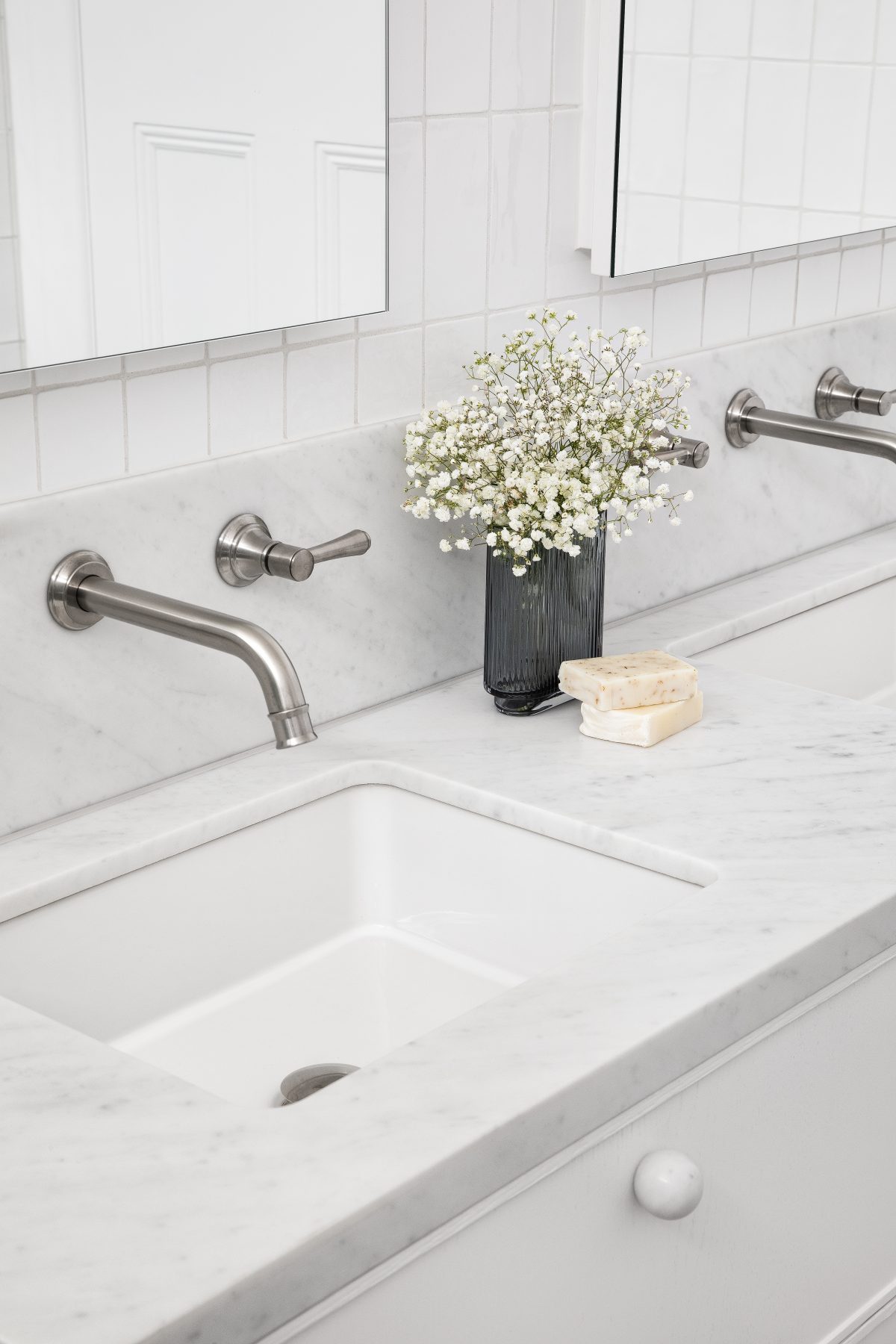 A custom designed bathroom featuring Spanish Handmade White Gloss tiles and a Carrara Marble bench top. Designed and built by MJ Harris Group.