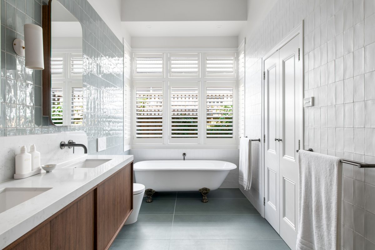 A custom designed bathroom featuring walnut joinery and Spanish handmade look tiles. Designed and built by MJ Harris Group.