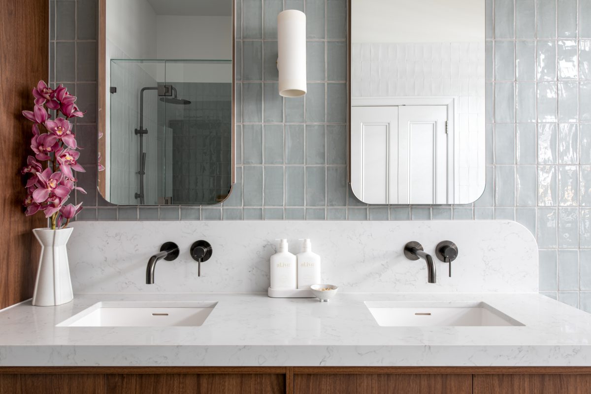 A custom designed bathroom featuring walnut joinery and Spanish handmade look tiles. Designed and built by MJ Harris Group.