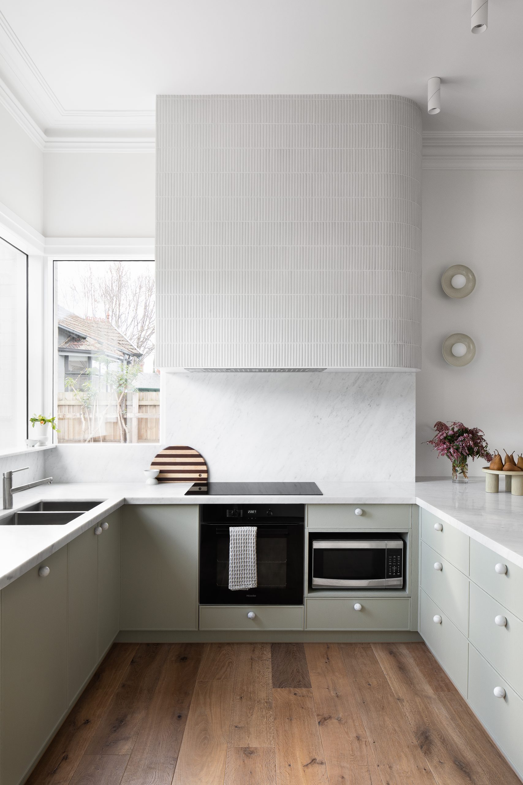 A custom designed kitchen featuring custom joinery in green and a Carrara Marble bench top. Designed and built by MJ Harris Group. #MJHxValentineGrove