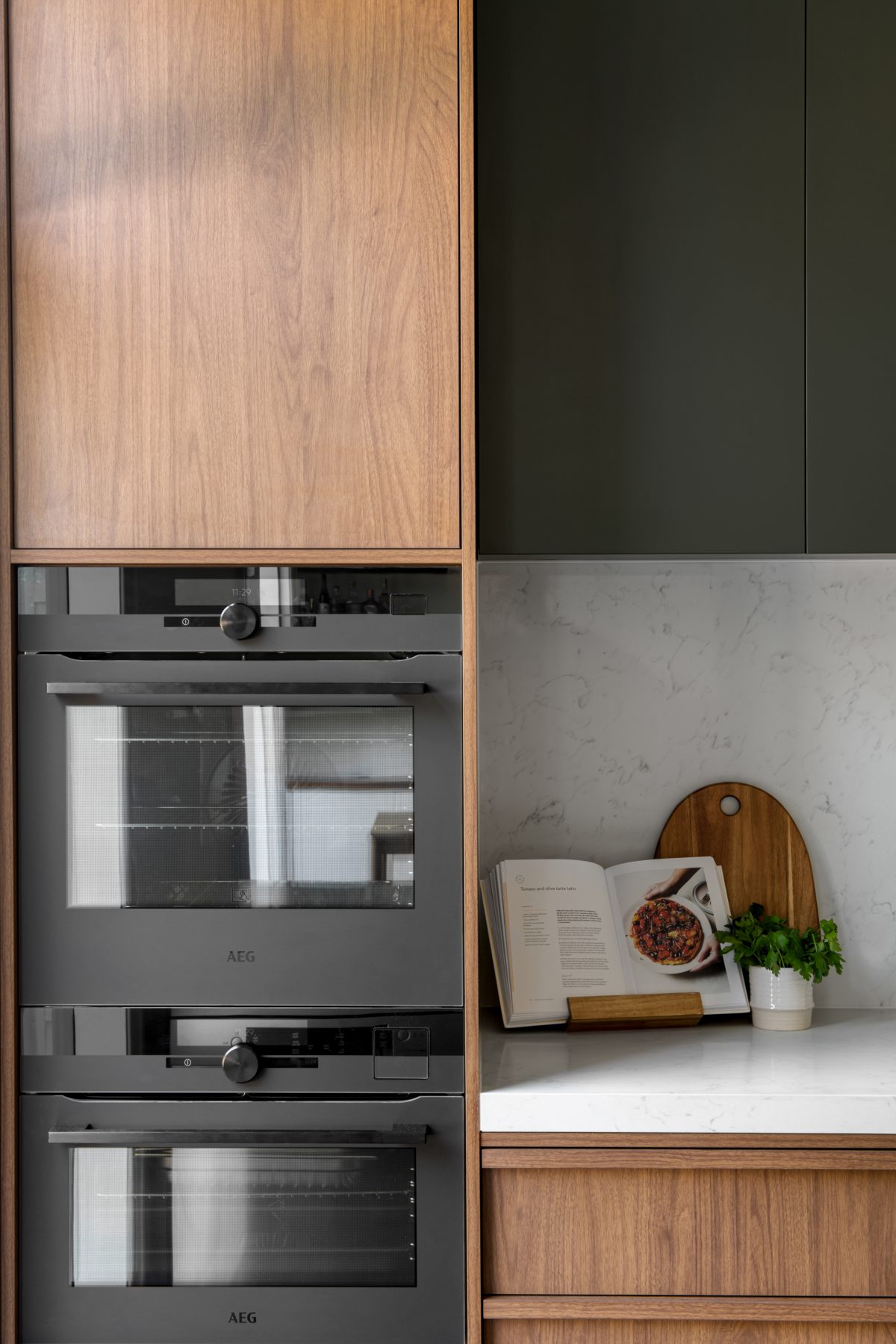 A custom designed kitchen featuring walnut joinery. Designed and built by MJ Harris Group.