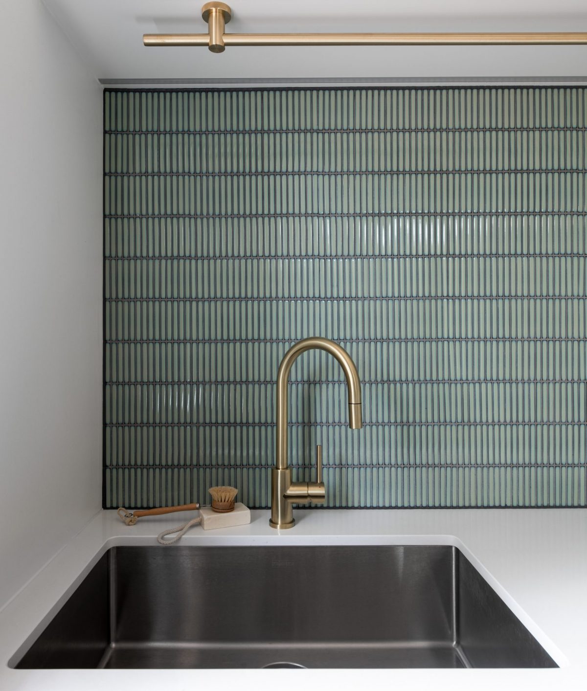 A custom designed kitchen featuring a tiled splash back in green. Built by M.J. Harris Group