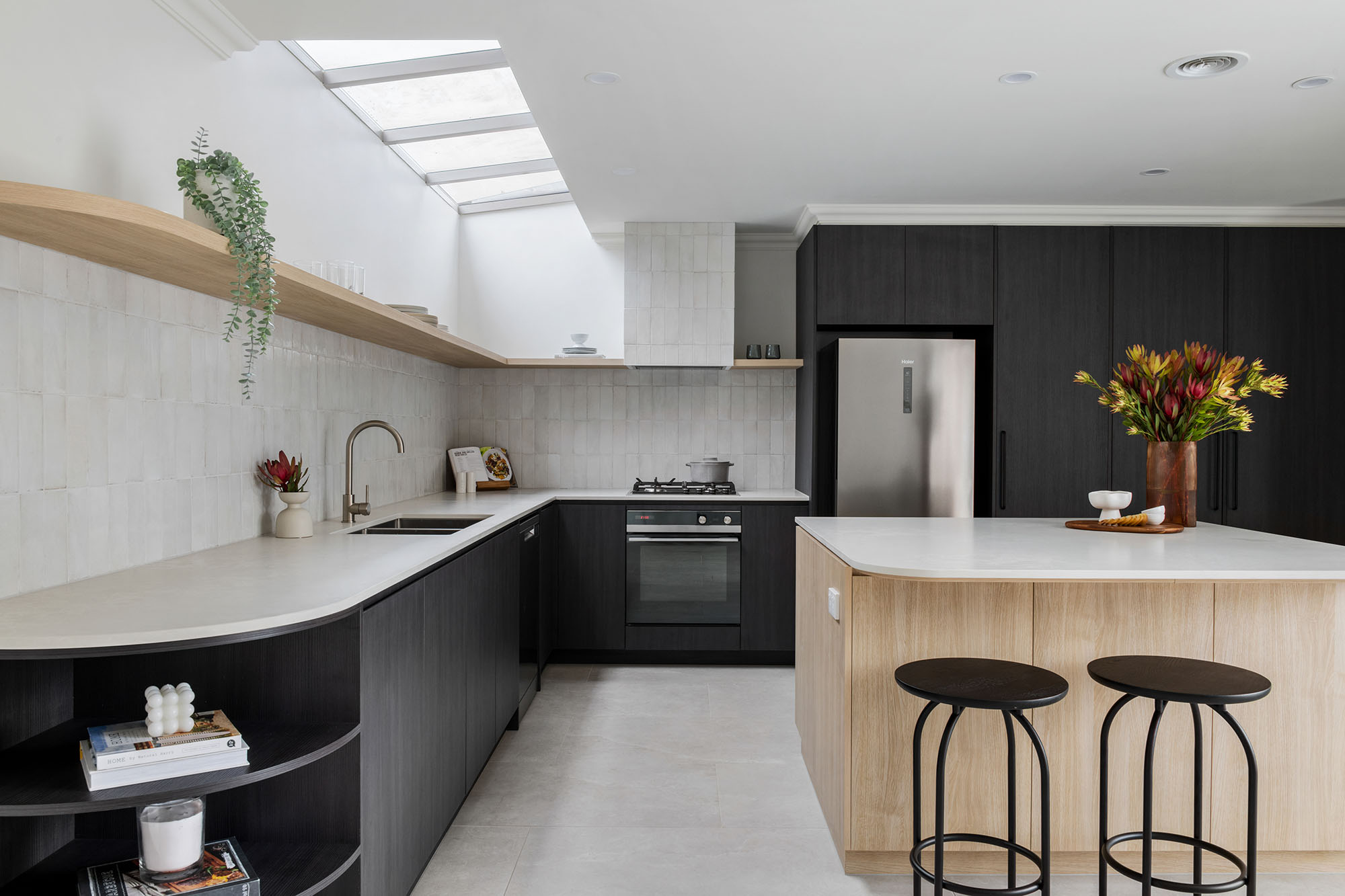 A custom designed kitchen featuring splashback tiles and contemporary curves. Designed and built by MJ Harris Group. #MJHxAndrewSt